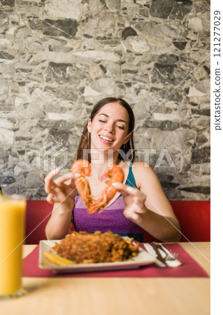 Woman making heart shape with shrimp at ecuadorian restaurant in madrid Woman making heart shape with shrimp at ecuadorian restaurant in madrid 121277029