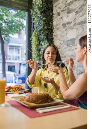 Women sharing traditional ecuadorian food in madrid restaurant Women sharing traditional ecuadorian food in madrid restaurant 121277033