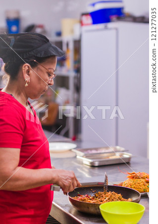 Latin american chef preparing traditional ecuadorian dish in restaurant kitchen Latin american chef preparing traditional ecuadorian dish in restaurant kitchen 121277035