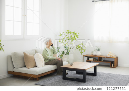 Senior woman making a phone call in the living room Senior woman making a phone call in the living room 121277531