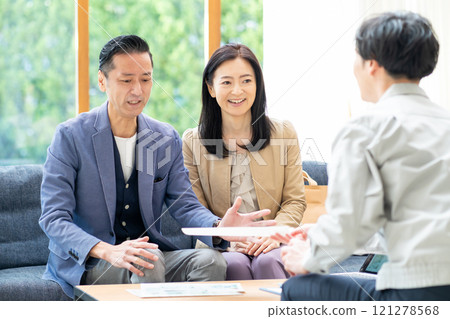 A salesman and a middle-aged couple discussing renovation plans 121278568