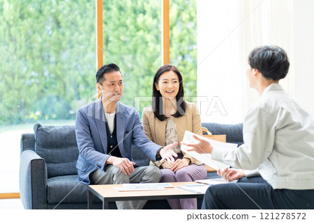 A salesman and a middle-aged couple discussing renovation plans A salesman and a middle-aged couple discussing renovation plans 121278572