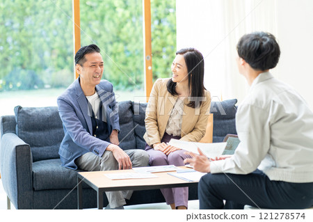 A salesman and a middle-aged couple discussing renovation plans A salesman and a middle-aged couple discussing renovation plans 121278574