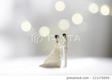 Couple in wedding dresses facing each other in the light Couple in wedding dresses facing each other in the light 121278899