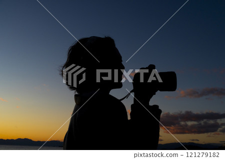 A woman holding a camera 121279182