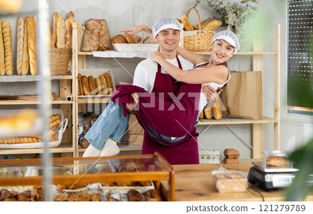 Girl and guy sellers in bakery are having fun and taking break from work, dancing and jumping. Girl and guy sellers in bakery are having fun and taking break from work, dancing and jumping. 121279789