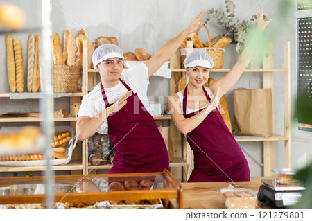 Young sellers standing in bake house, ready to greet customers Young sellers standing in bake house, ready to greet customers 121279801