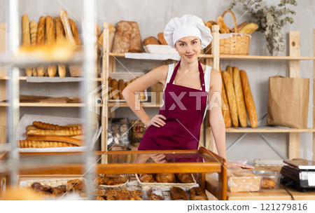 Young female seller standing in bake house, ready to greet customers 121279816