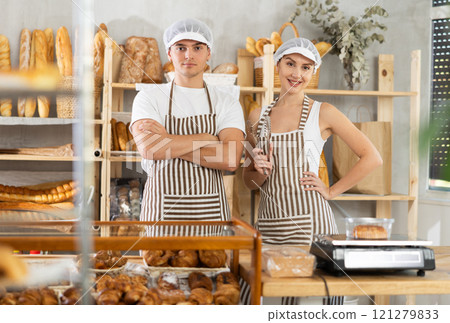 Successful team of bakery sellers posing behind counter 121279833