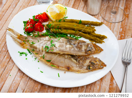 Fried roosterfish with asparagus, tomatoes and lemon 121279932