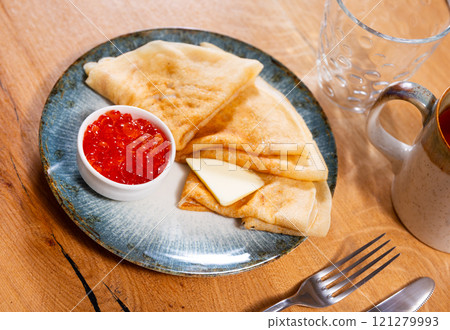 Pancakes served with red caviar and butter Pancakes served with red caviar and butter 121279993