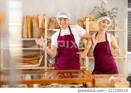 Woman and man sellers dance at counter in bakery Woman and man sellers dance at counter in bakery 121280018