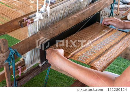 The traditional weaving of handmade cotton on the manual wood loom in Thailand. 121280124