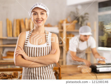 Young female seller standing in bake house, ready to greet customers Young female seller standing in bake house, ready to greet customers 121280146