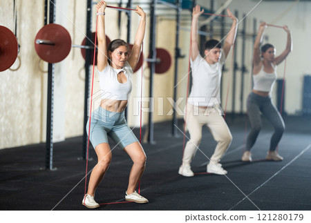 Group CrossFit classes - people doing sports with elastic bands Group CrossFit classes - people doing sports with elastic bands 121280179