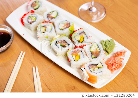 Sushi roll with salmon, avocado and cucumber inside, tobiko caviar outside. Sushi roll with salmon, avocado and cucumber inside, tobiko caviar outside. 121280204