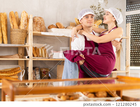 Young guy seller lifted female seller in his arms 121280245