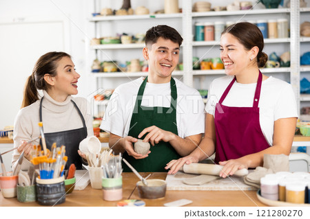 Two young women and young man making pottery Two young women and young man making pottery 121280270