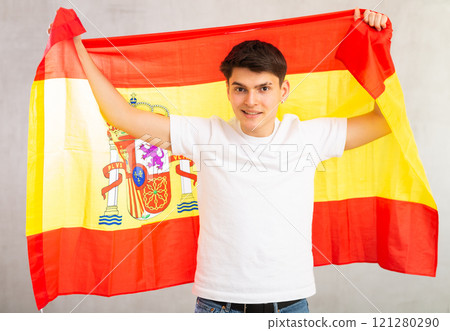 Portrait of young male supporter of the Spanish team wearing national flag 121280290