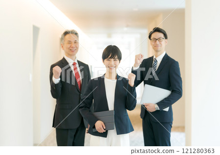 Men and women of a suit wearing a guts pose Men and women of a suit wearing a guts pose 121280363