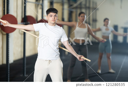 Young guy doing warm-up with stick 121280535