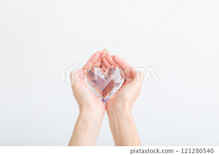 Hands holding a crystal heart 121280540
