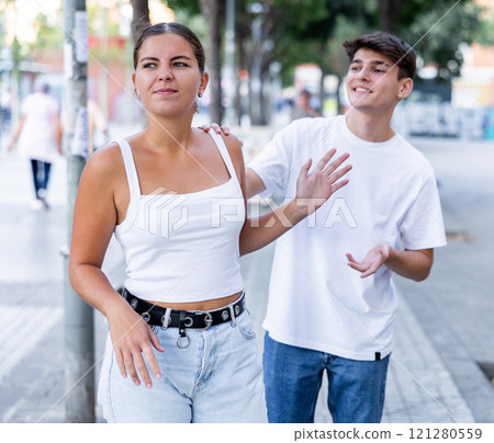Displeased girl stopping stranger guy flirting with her on city street 121280559