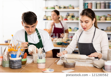 Young woman and young man making pottery 121280562