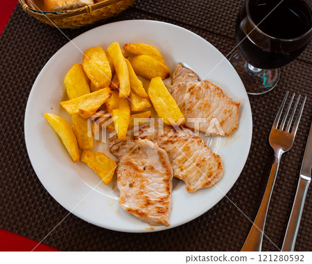 Fried pork and potato pieces served in a plate 121280592