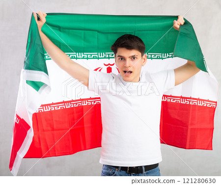 Young man holding the Iran flag in her hands Young man holding the Iran flag in her hands 121280630