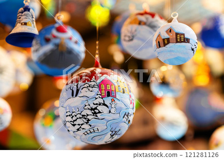 Christmas tree baubles hanging on christmas market stall, festive decorations 121281126