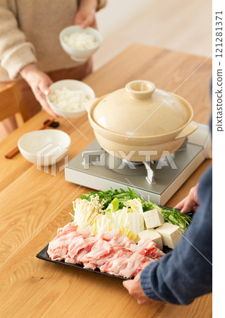 A middle-aged couple enjoying pork shabu-shabu hotpot at home 121281371