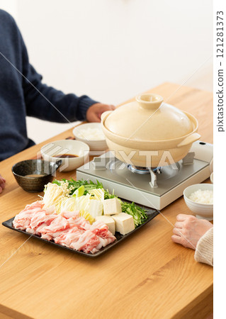 A middle-aged couple enjoying pork shabu-shabu hotpot at home A middle-aged couple enjoying pork shabu-shabu hotpot at home 121281373