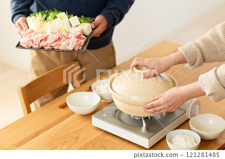 A middle-aged couple enjoying pork shabu-shabu hotpot at home 121281485