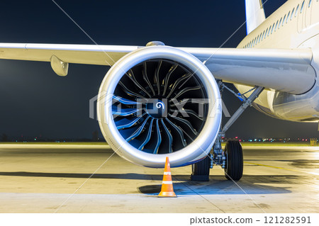 Close-up of engine of big white passenger jet plane at night 121282591