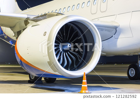 Close-up of engine of big white passenger airplane at night 121282592