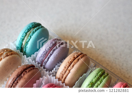 Bright colorful cakes French Macarons with white paperpan in plastic box Bright colorful cakes French Macarons with white paperpan in plastic box 121282881
