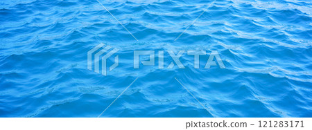 Calm blue ocean waves, peaceful sea surface, marine texture, tranquil water, serene aquatic scenery, natural background, blue water ripples, oceanic patterns 121283171