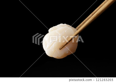 Scallop sashimi picked up with chopsticks Scallop sashimi picked up with chopsticks 121283203
