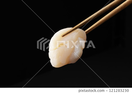 Scallop sashimi picked up with chopsticks 121283230