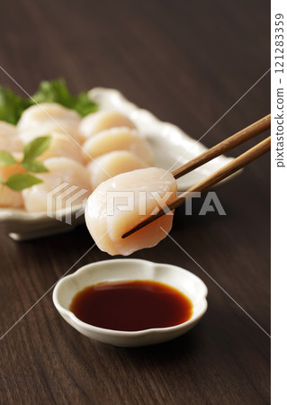Dip scallop sashimi in soy sauce 121283359