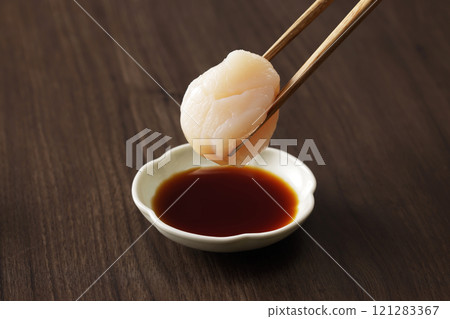 Dip scallop sashimi in soy sauce 121283367
