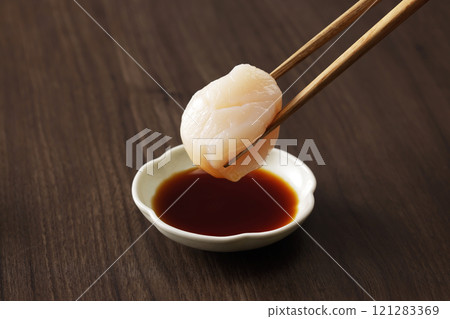 Dip scallop sashimi in soy sauce 121283369