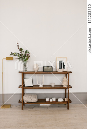Wooden shelf with a vase and a picture on it in living room 121283810