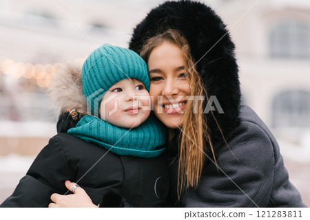 Young woman and a child are smiling at the camera at winter 121283811