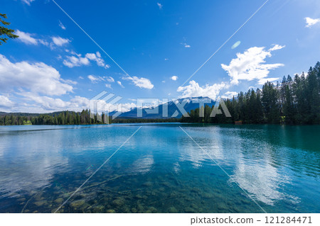Jasper National Park summer landscape, Alberta, Canada. Lakeside of the Beauvert Lake (Lac Beauvert), snowcapped Whistlers Peak mountain in the background. Jasper National Park summer landscape, Alberta, Canada. Lakeside of the Beauvert Lake (Lac Beauvert), snowcapped Whistlers Peak mountain in the background. 121284471