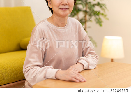 冬夜，穿著睡衣的中高級女性在客廳微笑 121284585