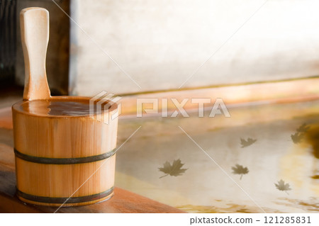 A cypress bucket placed in an open-air cypress bath, autumn leaves floating on the water, graphic image material of fallen leaves 121285831