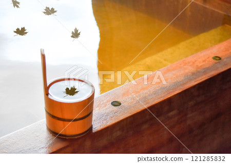 A cypress bucket placed in an open-air cypress bath, autumn leaves floating on the water, graphic image material of fallen leaves A cypress bucket placed in an open-air cypress bath, autumn leaves floating on the water, graphic image material of fallen leaves 121285832