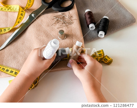 Sewing tools and supplies. Threads, scissors, fabric, and measuring tape 121286477